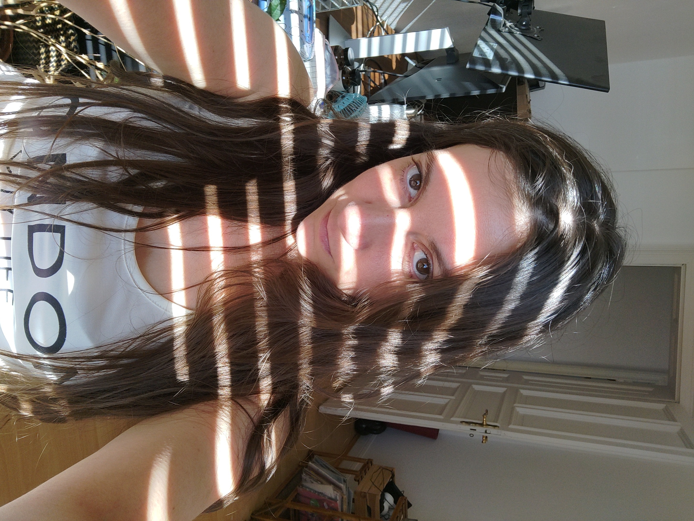 Selfie with the sun coming through rolling curtains on my face.